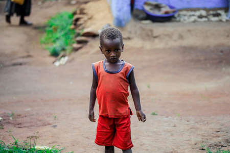 Jinka, Ethiopia - November 30, 2020: Little African Boy in Bright Clothes Looks at the Camera