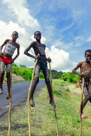Omo River Valley, Ethiopian -November 2020: Young Boys of Benna Tribe with Traditional Body Painting on the Long Wooden Sticks posing for the pictureのeditorial素材