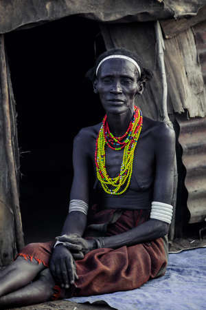 Omo River Valley, Ethiopia - November 30, 2020: Dassanech Tribe Old Woman with Traditional Bright Necklace in the Local Villageのeditorial素材