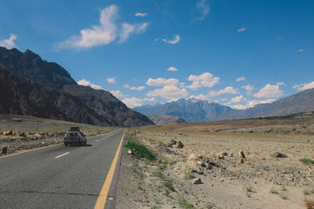 Asphalt Road in the High Gilgit Baltistan Mountains under the Blue Clouds, Pakistanの写真素材