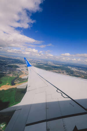Dubai, United Arab Emirates - June 10, 2021: Window View to the Aircraft Wing and Cloudy Blue Skyのeditorial素材