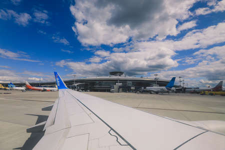 Dubai, United Arab Emirates - June 10, 2021: Window View to the Aircraft Wing and Cloudy Blue Skyのeditorial素材