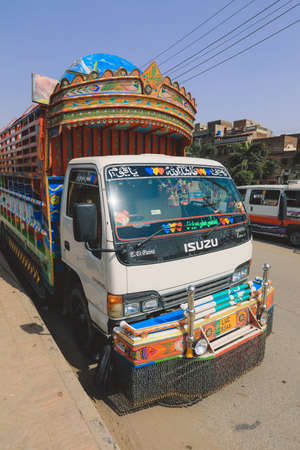 Lahore, Pakistan - July 08, 2021: Bright and Colorful Yellow Pakistani Truck with traditional Decorations and Design on the Lahore Streetのeditorial素材