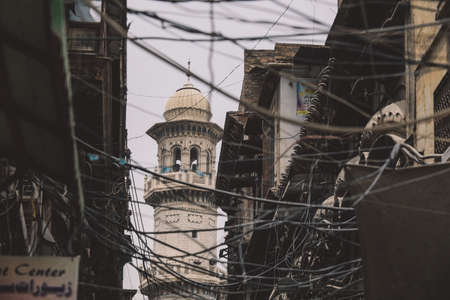 View to the White Mosque Minaret and Wires in the Peshawar City Center Street, Pakistanの写真素材
