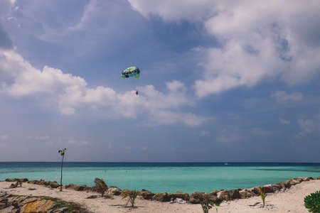 Maafushi, Maldives - June 25, 2021: People near the White Sandy Beach with the Palm Trees and Hotel Building on the Maldivian Paradise Islandのeditorial素材