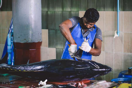 Male, Maldives - June 25, 2021: Local Maldivian Fisherman butcher a Big Tuna Fish on the Central Market of Male Cityのeditorial素材