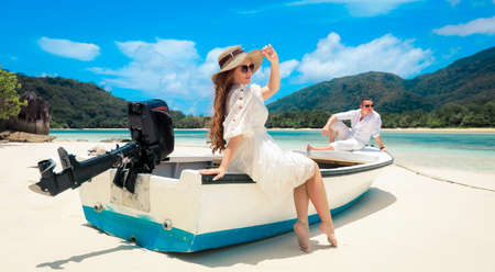 Two lovers and a boat on the paradise Seychellesの写真素材
