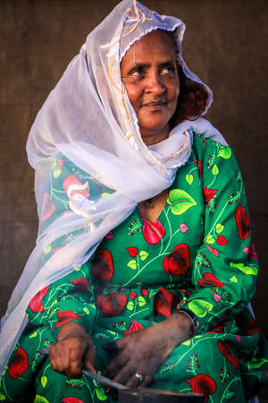 Eritrea, Asmara - November 14, 2021: Local Old Woman in White Scarf and Bright Green Dress in Asmaraのeditorial素材