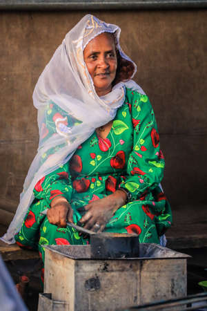 Eritrea, Asmara - November 14, 2021: Local Old Woman in White Scarf and Bright Green Dress in Asmaraのeditorial素材
