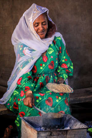 Eritrea, Asmara - November 14, 2021: Local Old Woman in White Scarf and Bright Green Dress in Asmaraのeditorial素材