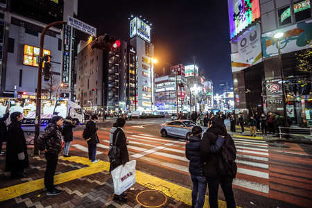 Tokyo, Japan - January 08, 2020: Tourists and Local People walking on the Beautiful Tokyo street among passing Cars in the Night timeのeditorial素材