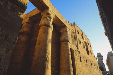 Sunset View to an Illuminated in Yellow Grand colonnade of large Ancient Egyptian temple in Luxor, Egyptの写真素材