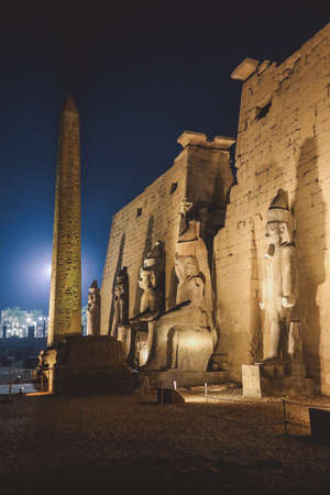 Sunset View to the Illuminated Stone Statues of the large Ancient Egyptian temple in Luxor, Egyptの写真素材