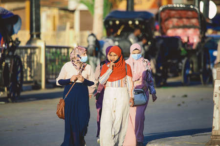Luxor, Egypt - November 12, 2020: Local Egyptian Young People in Traditional Arabian Dress walking near Nile River Ferry Portのeditorial素材