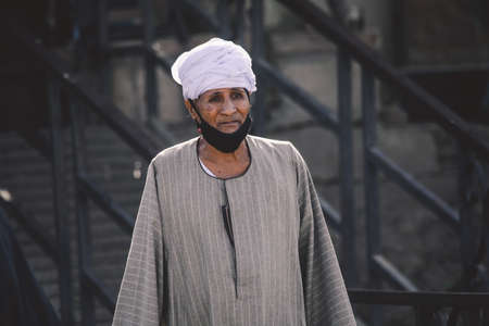 Luxor, Egypt - November 12, 2020: Local Egyptian Old Woman in Traditional Arabian Dress going to...