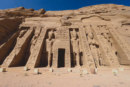 The main view of an Entrance to the Great Temple at Abu Simbel with Ancient Colossal statues of Ramesses II, seated on a throne and wearing the double crown of Upper and Lower Egypの写真素材