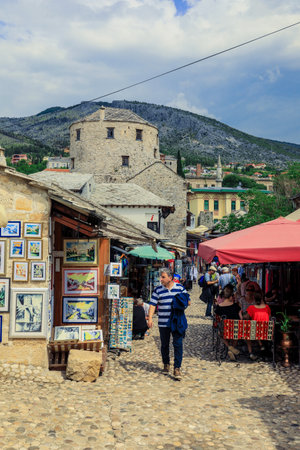 Mostar, Bosnia and Herzegovina - May 12, 2022: Old Town in city center of Mostar with the Colorful Traditional Souvenirs with Walking Touristsのeditorial素材