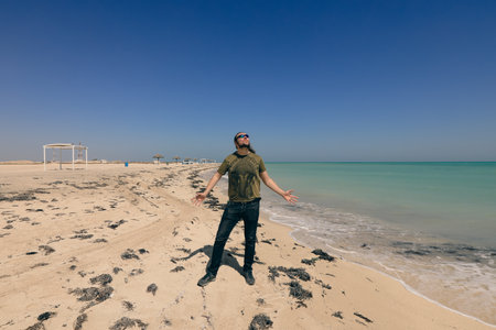 White Tall Man Tourist on the Sandy Beach of the Persian Gulf, Qatarの写真素材