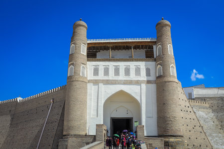 Bukhara, Uzbekistan - May 05, 2022: View to the Tourists near the Entrance Gates of the Ark, the Medieval massive Bukhara Fortress in Uzbekistanのeditorial素材