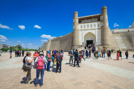 Bukhara, Uzbekistan - May 05, 2022: View to the Tourists near the Entrance Gates of the Ark, the Medieval massive Bukhara Fortress in Uzbekistanのeditorial素材