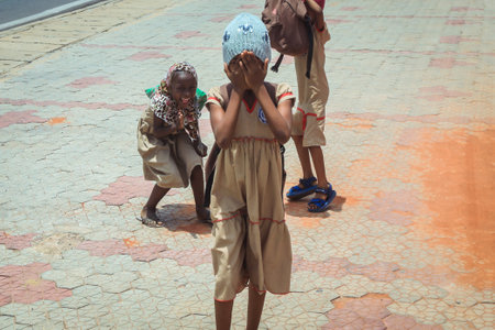 Lome, Togo - March 05, 2023: Two African Schoolgirls  are going home from the Lessonsのeditorial素材
