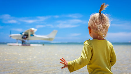 Small Child on Beach Looking at Airplaneの写真素材