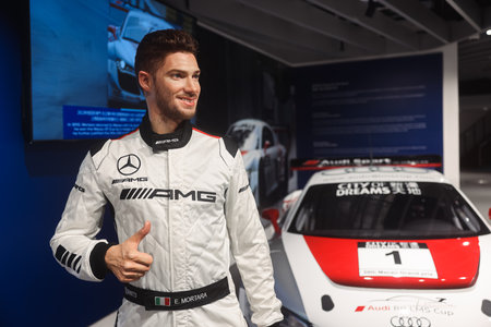 Macao, China - May 20, 2023: Man Giving Thumbs Up in Front of Car at Macao Formula 1 Museum