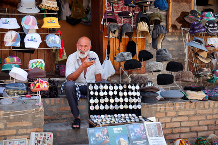 Man Sitting on Step in Front of Hat Shopのeditorial素材