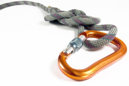 A locking carabiner and a figure eight follow through knot is isolated against a white back ground