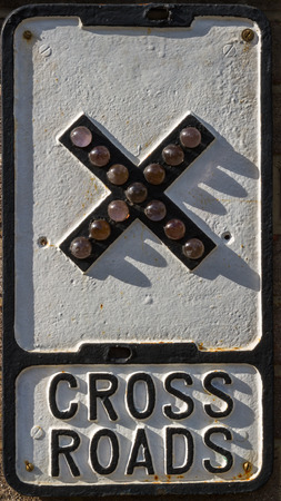 An old British road sign showing cross roads warningの写真素材