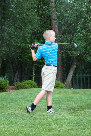 Young male teen golfer mid-swing with exemplary formの写真素材