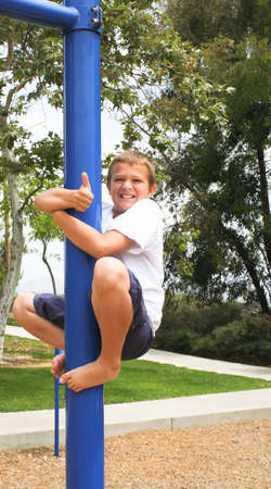 happy Boy on pole with thumbs up signの写真素材