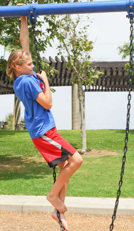 determined teenage girl climbing swing chainの写真素材