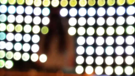 Female DJ with lighing from behind the set. The light is a pattern of white, green and yellow dots around the silhouette of the female DJの写真素材