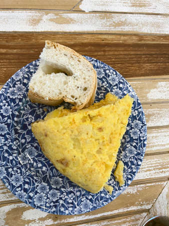 Spanish omelette on a dish with a slice of bread