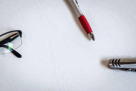 pen, glasses and pocket knife isolated in the corners on white backgroundの写真素材