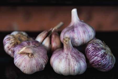 garlic bulb on top of a dark wooden benchの写真素材