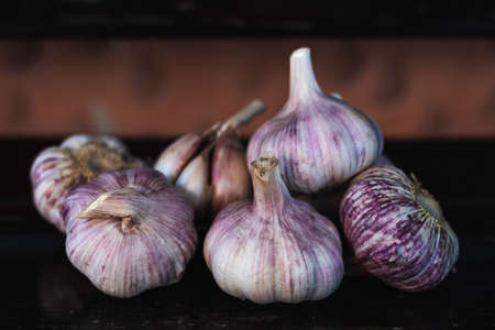 garlic bulb on top of a dark wooden benchの写真素材