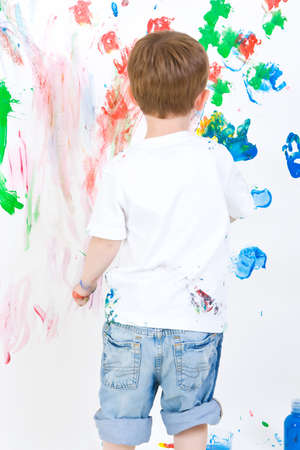 Three year old boy reviewing his wall paintingの写真素材