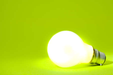 Illuminated light bulb on green implying green energy