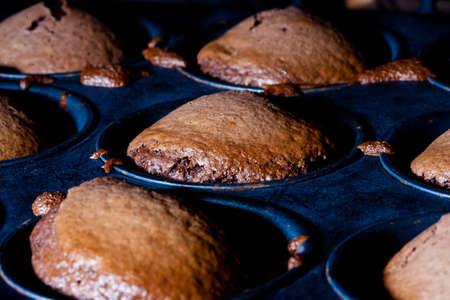 Chocolate chip muffins baking in the ovenの写真素材
