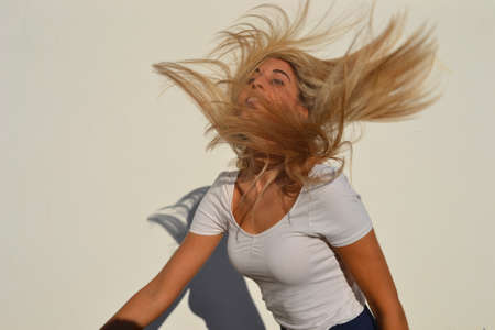 Pretty woman with long blond hair in wind.