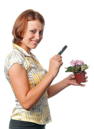Smiling girl considers violets through a magnifierの写真素材