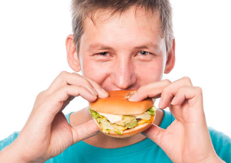 Hungry young man eating a hamburger