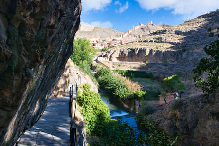 Hiking river route along the Guadalaviar river with the town and walls of Albarracin in the background, Teruelの写真素材