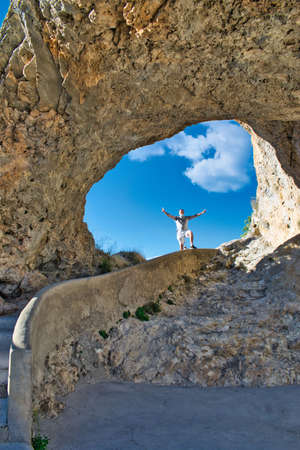 Peeking out with his arms crossed in the viewpoint of Ventano del Diablo in Cuenca, Spainの写真素材