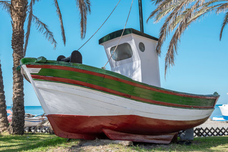 Small and old fishing boat exposed as a monument on the seafront of the coastal town of AlmuÃ±ecar, Spainの写真素材