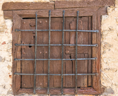Old wooden window with wrought iron bars, traditional architecture in the village of Candelario, Spainの写真素材