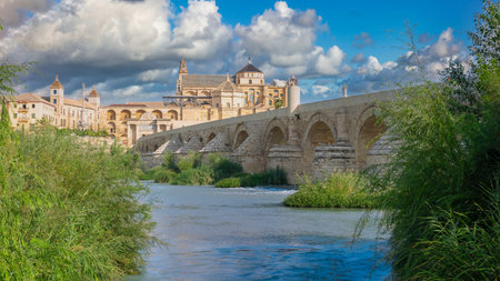 View of the Guadalquivir River, Roman bridge and the cathedral mosque of Cordoba, Spain. With edited skyの写真素材