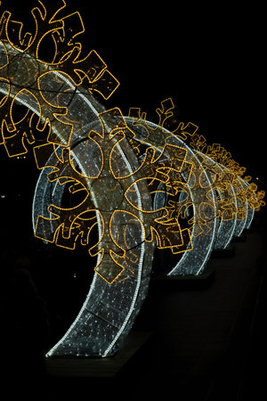 Tunnel of arches with bright Christmas lights on one side of the cathedral in Valladolid, Spainの写真素材
